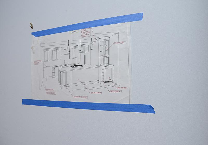 Plans for the kitchen are taped to the wall.